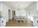 Bright dining area with a chandelier, modern table set, and sliding glass doors to the outside at 2320 Marks Creek Rd, Knightdale, NC 27545