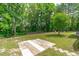 Enjoy the backyard featuring a stone patio and mature trees for privacy at 2575 Primrose Ln, Creedmoor, NC 27522
