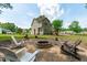 A wonderful backyard with a brick firepit and chairs, with a view of the home at 2575 Primrose Ln, Creedmoor, NC 27522