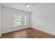 Simple bedroom featuring a large window, wood flooring, and ceiling fan at 2575 Primrose Ln, Creedmoor, NC 27522
