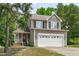 Charming two-story home featuring a large front yard, a two-car garage, and mature trees at 2575 Primrose Ln, Creedmoor, NC 27522