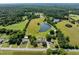 Aerial view showing the property with a private pond, surrounding greenery, and outbuildings at 2637 S Nc 87, Graham, NC 27253