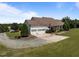 Expansive home with a three-car garage, large driveway, and mature landscaping on a lush green lawn at 2637 S Nc 87, Graham, NC 27253