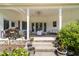 Covered patio area featuring comfortable seating, ceiling fan, grill, and decorative potted plants for outdoor enjoyment at 2637 S Nc 87, Graham, NC 27253