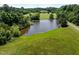 A beautiful view of a house overlooking a large pond, surrounded by lush green grass and trees at 2637 S Nc 87, Graham, NC 27253