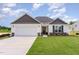 Charming single-story home featuring a two-car garage, manicured lawn, and stone accents at 30 Chloe Ct, Selma, NC 27576