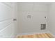 Clean, well-lit laundry room with utility connections and hardwood flooring at 30 Chloe Ct, Selma, NC 27576