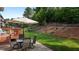 Backyard patio with an outdoor dining set, an umbrella, and a beautifully maintained yard at 3032 Curling Creek Drive Dr, Apex, NC 27502