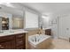 Luxurious bathroom featuring a large soaking tub, dual vanities, and bright natural light at 3032 Curling Creek Drive Dr, Apex, NC 27502