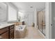 Well-appointed bathroom with a soaking tub, glass-enclosed shower, and neutral tile flooring at 3032 Curling Creek Drive Dr, Apex, NC 27502