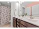 Bathroom with a double vanity, framed mirror, and floral shower curtain over the tub at 3032 Curling Creek Drive Dr, Apex, NC 27502