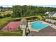 Aerial view featuring a community pool, pool house, basketball court, and a serene pond surrounded by lush trees at 3032 Curling Creek Drive Dr, Apex, NC 27502