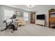 Bright exercise room featuring a stationary bike, TV, desk, and natural light, promoting an active lifestyle at 3032 Curling Creek Drive Dr, Apex, NC 27502