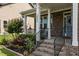 Inviting front porch with brick steps, white columns, and a beautifully landscaped garden at 3032 Curling Creek Drive Dr, Apex, NC 27502