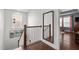 Hallway on the second floor with wood floors, white railing and walls, plus a large decorative mirror at 3032 Curling Creek Drive Dr, Apex, NC 27502