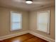 Bedroom features hardwood floors and two windows with white blinds at 306 Penny St, Garner, NC 27529