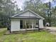 White cottage style home with dark metal roof and covered front porch at 306 Penny St, Garner, NC 27529