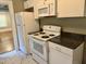 Modern kitchen featuring white appliances, granite countertops, and a view into the living area at 306 Penny St, Garner, NC 27529