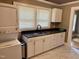 Well-lit kitchen showcasing white cabinetry, granite countertops, sink, and a stacked washer and dryer at 306 Penny St, Garner, NC 27529