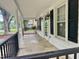 Covered front porch with black railings, white columns, and outdoor lighting fixtures at 306 Penny St, Garner, NC 27529