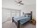 Bright bedroom features a ceiling fan, large windows, and a comfy bed with blue bedding and decor at 3101 Riverbrooke Dr, Raleigh, NC 27610