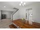 Open-concept dining room featuring a modern chandelier, and adjacent living room and stairway at 3101 Riverbrooke Dr, Raleigh, NC 27610