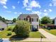 Charming two-story home features a red door, brick accents, a small balcony, and a well-maintained lawn at 3101 Riverbrooke Dr, Raleigh, NC 27610