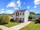 Charming two-story home features a red door, brick accents, a small balcony, and a well-maintained lawn at 3101 Riverbrooke Dr, Raleigh, NC 27610