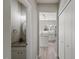 Hallway view of the kitchen with white cabinetry, stone countertops and stainless appliances, with a 1/2 bath to the left at 3101 Riverbrooke Dr, Raleigh, NC 27610