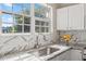 Bright kitchen sink with marble backsplash, granite counters and a large window over sink at 3101 Riverbrooke Dr, Raleigh, NC 27610
