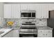 Close up of modern, stainless appliances and granite countertops in a bright kitchen at 3101 Riverbrooke Dr, Raleigh, NC 27610