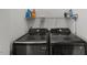 Well-lit laundry room features modern, front-loading washer and dryer with storage shelf above for supplies at 3101 Riverbrooke Dr, Raleigh, NC 27610