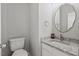 Half bath features a granite countertop, modern faucet and a decorative framed mirror at 3101 Riverbrooke Dr, Raleigh, NC 27610