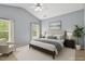 A serene bedroom with light blue walls, a plush bed, and bright windows, creating a relaxing retreat at 320 Madres Ln, Morrisville, NC 27560