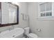 Neutral bathroom features a white sink, toilet, and window at 3310 Mission Olive Pl, New Hill, NC 27562