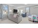 Well-lit bedroom features a cozy seating area, a large screen TV and soft, neutral colors at 3310 Mission Olive Pl, New Hill, NC 27562
