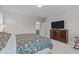 Spacious bedroom features floral bedding, hardwood floors, and an ensuite bathroom at 3310 Mission Olive Pl, New Hill, NC 27562