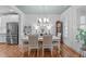 Elegant dining area with a white table, chandelier, and hardwood floors at 3310 Mission Olive Pl, New Hill, NC 27562