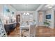 Bright dining room featuring hardwood floors, a chandelier, and windows for natural light at 3310 Mission Olive Pl, New Hill, NC 27562