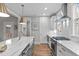 This kitchen has white cabinets, a stainless vent hood, stone countertops, and an undermount farmhouse sink at 3310 Mission Olive Pl, New Hill, NC 27562