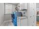 Well-lit laundry room with blue washer-dryer, white cabinets, and granite countertop at 3310 Mission Olive Pl, New Hill, NC 27562