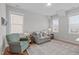 Cozy living room featuring a rocking chair, sofa and two large windows at 3310 Mission Olive Pl, New Hill, NC 27562
