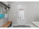Mudroom featuring a bench, coat hooks, shelving, a windowed back door, and stone countertops at 3310 Mission Olive Pl, New Hill, NC 27562