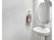 Elegant powder room with a pedestal sink, oval mirror, and modern fixtures at 333 Natsam Woods Way, Wake Forest, NC 27587