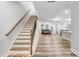 Bright entryway featuring hardwood floors, a staircase with wooden handrail, and views to the living area at 333 Natsam Woods Way, Wake Forest, NC 27587