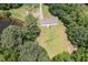 Aerial view of a quaint house with a large, grassy backyard surrounded by lush trees and proximity to a pond at 3336 Piney Grove Wilbon Rd, Fuquay Varina, NC 27526