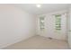 Bright bedroom with neutral carpet, two windows, and white trim around the door and windows at 3336 Piney Grove Wilbon Rd, Fuquay Varina, NC 27526