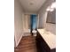 Well-lit bathroom features a shower with blue curtains, a single sink vanity, and modern fixtures at 3624 Meadow Creek Ln, Raleigh, NC 27616