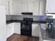 Modern kitchen with white cabinetry, gray backsplash, black appliances, and sleek countertops creating a clean and stylish space at 3624 Meadow Creek Ln, Raleigh, NC 27616
