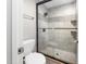 Bathroom featuring a glass-enclosed shower with decorative tile and gray ceramic tiling at 3811 Cottonwood Dr, Durham, NC 27705